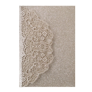 Macro view of champagne gold glitter laser-cut invitation with elegant lace details