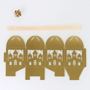 Flat lay of laser-cut gold gift box template with castle silhouette and ribbon