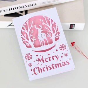 Detailed laser-cut reindeer and snowflake patterns on elegant white Christmas card
