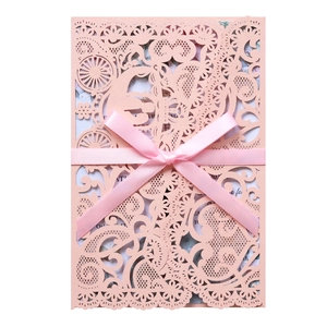 Detailed laser-cut hollow pink lace wedding invitation with silk bow and floral inserts