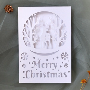 Detail of laser-cut reindeer and Merry Christmas lettering on white greeting card