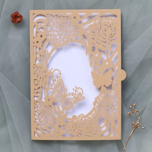 Macro view of laser-cut rose and butterfly hollow detail on kraft invitation card