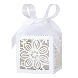 Detail van wit lasergesneden snoepdoosje met elegant zijden lint voor bruiloften