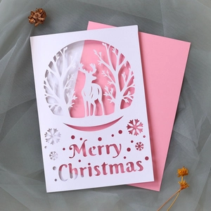 Detail of laser-cut Christmas card with reindeer, forest, and Merry Christmas text