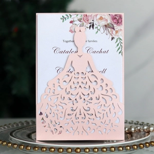 Macro detail of laser-cut wedding dress silhouette on pink pearlescent paper invitation