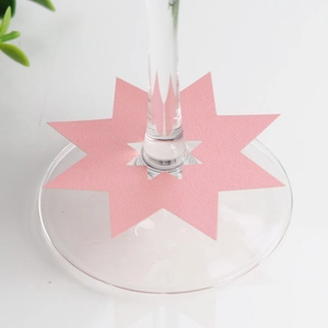 Roze achthoekige papieren plaatskaartjes voor wijnglazen en bruiloftstafeldecoratie