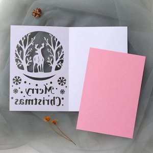 Close-up of laser-cut reindeer and Merry Christmas text on a white holiday card