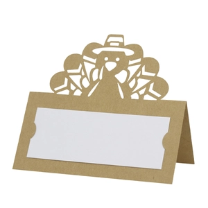 Detail of laser-cut turkey place card made of brown kraft paper for holiday table setting