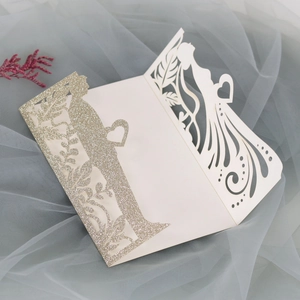 Λεπτομέρεια προσκλητηρίου γάμου laser-cut με χρυσό γκλίτερ και σιλουέτες νύφης και γαμπρού