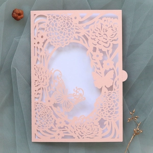 Detailed laser-cut rose and butterfly invitation card on elegant blue tulle backdrop
