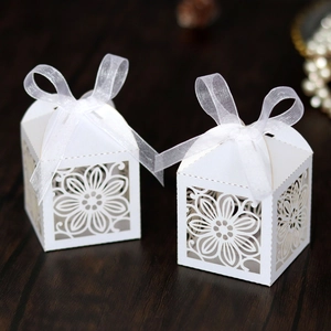 Detail van lasergesneden snoepdoos met hibiscuspatroon en decoratieve witte organza strik