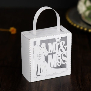 Détail de la découpe laser Mr & Mrs sur une boîte cadeau de mariage blanche avec anse