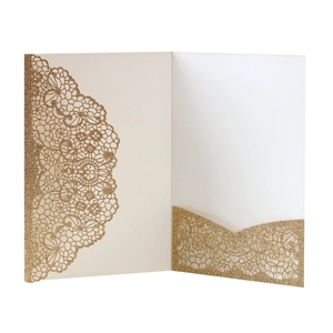 Detail of glitter gold laser-cut invitation card with intricate lace hollow-out pocket