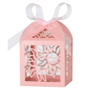 Close-up of pink hollow house-shaped candy box with intricate laser-cut sun patterns