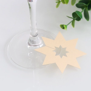 Detail van een stervormige parelmoer papieren wijnglasmarker voor bruiloftsdecoratie