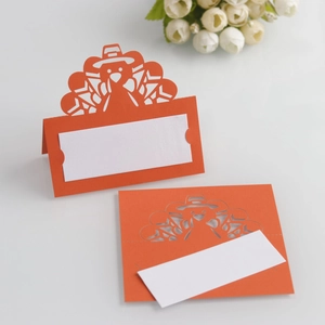Detailed laser-cut orange turkey place cards with white name cards for table setting