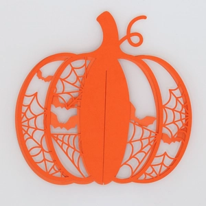 Detail of orange hollow pumpkin decoration with laser-cut spider web and bat patterns