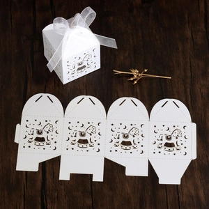 Macro view of white laser-cut rocking horse gift box with elegant ribbon and paper craft