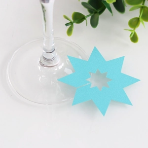 Detail van een ster-vormige turquoise papieren wijnglaskaart met ster-uitsparing