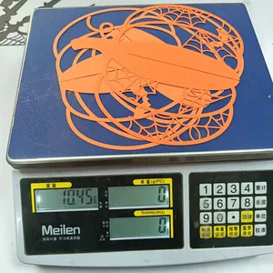 Close-up of lightweight orange Halloween pumpkin paper decor weighing 10.45g on a scale