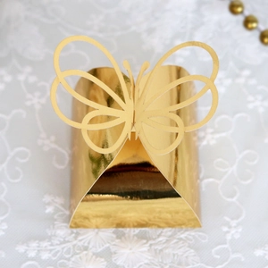 Top view of a gold hollow butterfly candy box with metallic luster on white lace