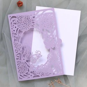 Close-up of laser-cut butterfly and floral patterns on lavender purple invitation card