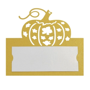Detail of laser-cut pumpkin place card with maple leaf design and white inner card