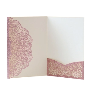 Detail of laser-cut rose gold glitter wedding invitation with floral lace hollow pattern