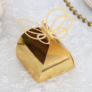 Detailed view of golden laser-cut butterfly gift box on elegant white lace fabric