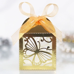 Makroaufnahme der goldenen lasergeschnittenen Schachtel mit Schmetterling und Satinband
