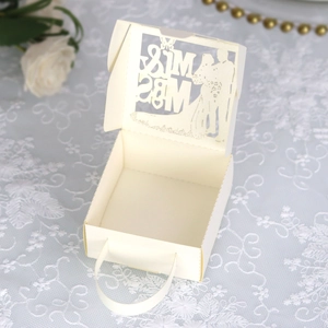 Détail de la boîte à dragées découpée au laser avec décor de dentelle et roses blanches