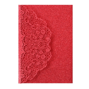 Macro view of laser-cut lace pattern on red glitter paper wedding invitation card