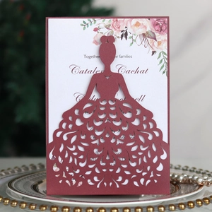 Detail of burgundy laser-cut wedding invitation featuring elegant gown pattern and floral insert