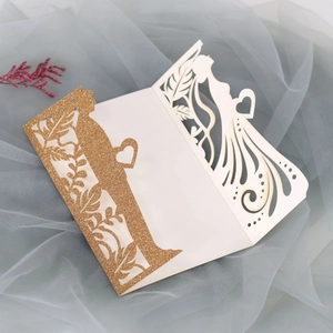 Λεπτομέρεια προσκλητηρίου γάμου laser-cut με χρυσό γκλίτερ και σιλουέτες του ζευγαριού