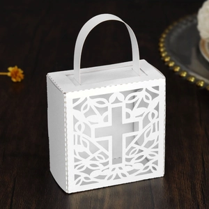 Detailed laser-cut white hollow cross gift box for weddings on elegant wooden surface