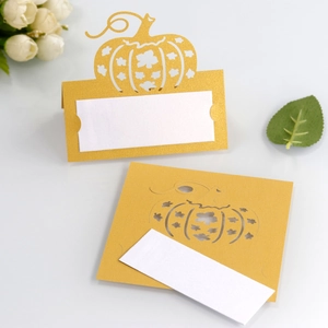 Detailed laser-cut pumpkin place cards with golden pearlescent finish for party seating