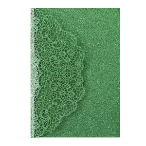 Detail of green glitter paper wedding card with laser-cut floral lace patterns