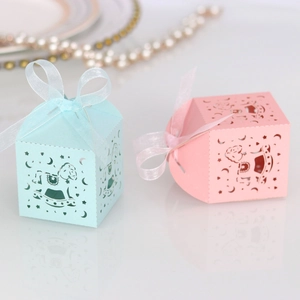 Detailed laser-cut rocking horse candy boxes in pink and blue with ribbons for parties