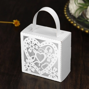 Detail van wit lasergesneden papieren geschenkdoos met hart- en bloemvormige patronen
