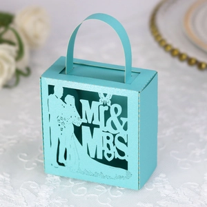 Détail d'une boîte de bonbons de mariage bleue découpée au laser avec silhouette de mariés