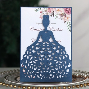 Detail of laser-cut navy wedding invitation featuring bridal dress design and floral inner page