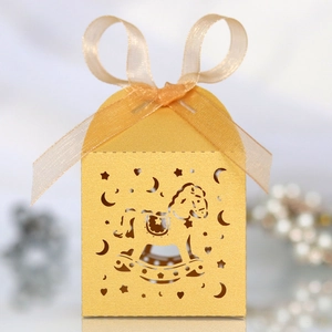 Detailed laser-cut rocking horse candy box in gold pearl paper with orange ribbon bow