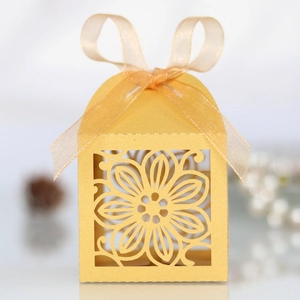 Detail van lasergesneden hibiscus bedankdoosje in goud parelmoer papier met lintje