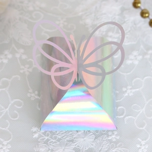Detail of laser-cut butterfly gift box with iridescent rainbow finish on lace background