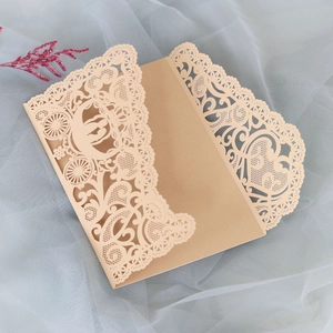 Detailed laser-cut heart and carriage lace patterns on champagne gold wedding invitation