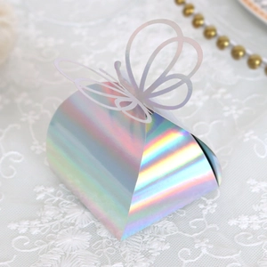 Detail of laser-cut hollow butterfly on holographic gold favor box with iridescent finish