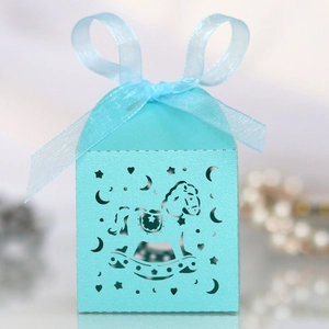 Detail of light blue laser-cut rocking horse candy box with matching organza ribbon bow