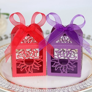 Detailed laser-cut sun pattern on pink and purple favor boxes with silk ribbon