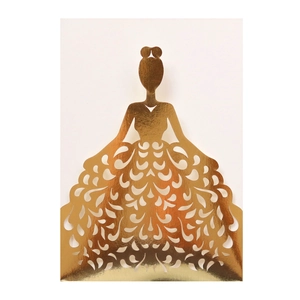 Detail of laser-cut gold wedding invitation featuring an elegant silhouette with heart patterns