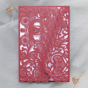 Close-up of wine red laser cut wedding invitation with pumpkin carriage and lace detail